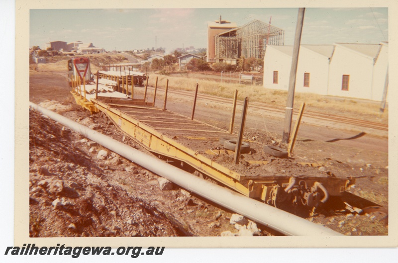 P16130
Y class diesel loco, QU class wagon in yellow livery, derailed on the runaway track on the Rocky Bay Line, State Engineering Works building on the right, CSBP plant being demolished in the background
