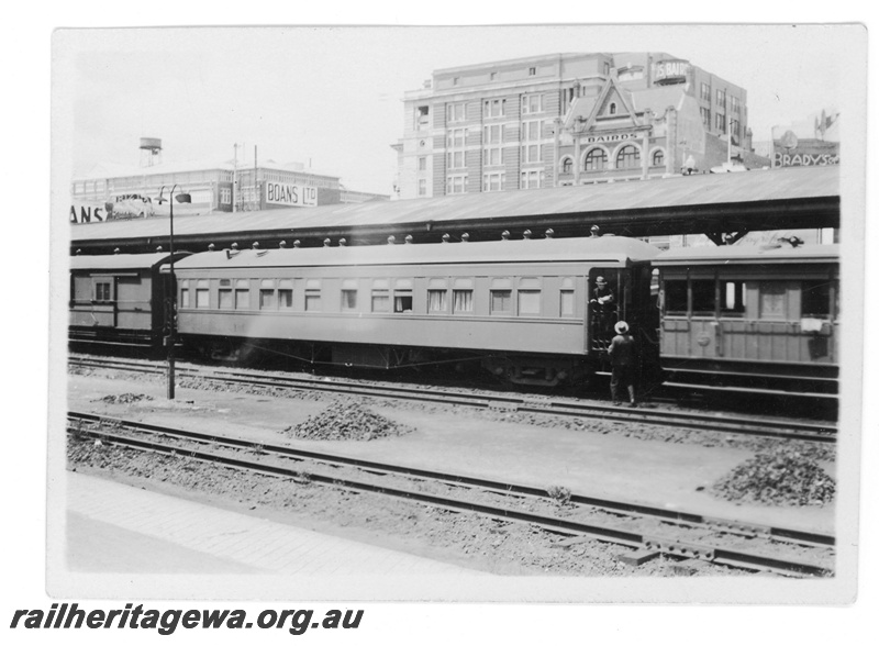 P16435
Passenger carriage with open platform ends, vans, Boans and Bairds buildings in background, canopy, Perth station, side view
