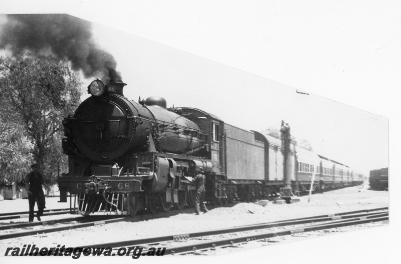 P16470
Commonwealth Railways (CR) G class 68, on passenger train, water column, workers, Rawlinna, TAR line, track level view
