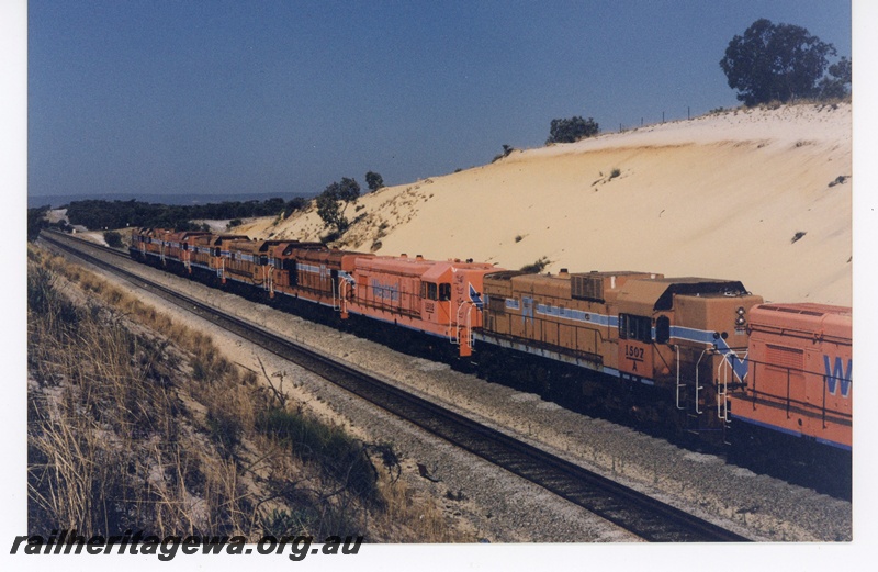 P16523
A class 1502, A class 1507, and several other diesels, all in Westrail orange with blue and white stripe, and all surplus to requirements, in cutting heading to North Fremantle for trans-shipment overseas, side and end views
