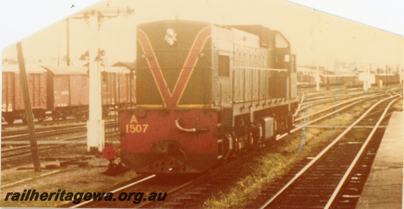 P16538
A class 1507 in green with red and yellow stripe, various wagons, signal, point lever, Perth station, end and side view
