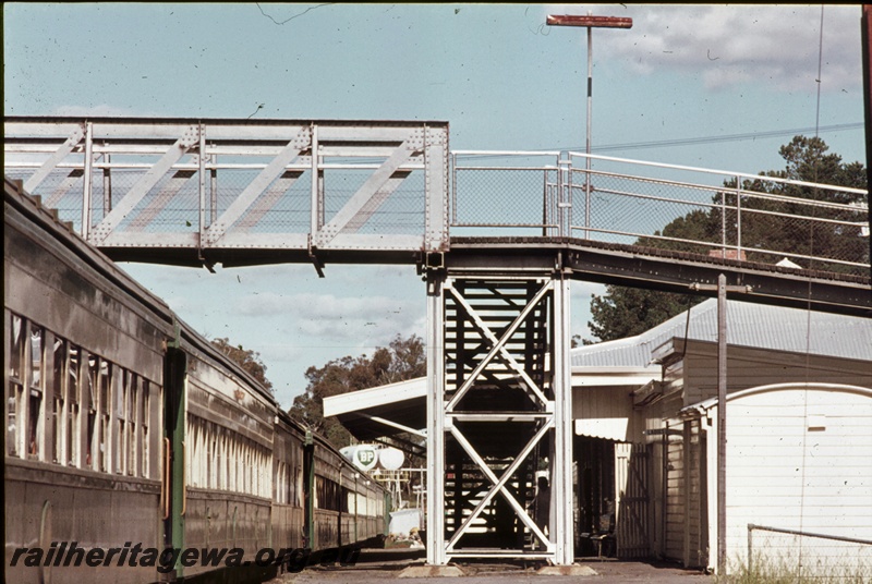 P16668
Pedestrian footbridge, station building, train standing at station, view along platform, Collie, BN line
