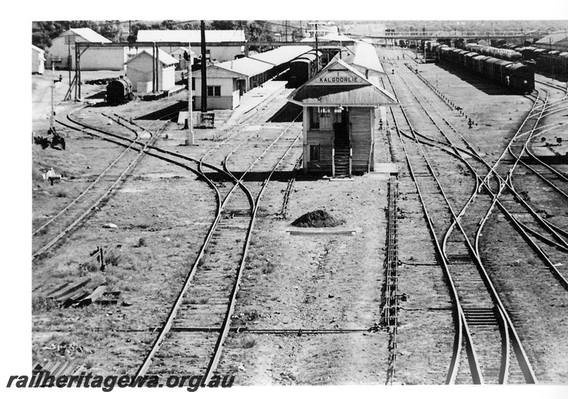 P16695
Overview of Kalgoorlie station and yard, station buildings, canopies, platforms, train standing at platform, signal, signal box, pedestrian footbridge, yard, rakes of wagons, pointwork, Kalgoorlie, EGR line, view from elevated position
