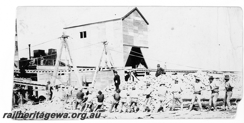 P16801
Commonwealth Railways (CR) - TAR line workers erecting buildings at Naretha. Quarry crushing plant in background. c1916
