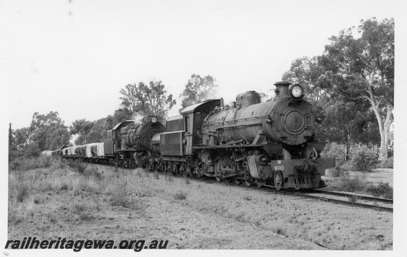P17369
W. class 910 and S class 544 steam locomotives on 104 goods between Muja and Collie. Front and side view of locomotives. BN line. Similar to P17368.
