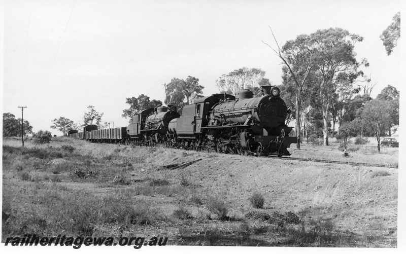P17376
W class 919 & 914 steam locomotives at the head of 54 Goods leaving Duranillin. BN line. Leading wagons are 4 wheeled open type returning to load superphosphate.
