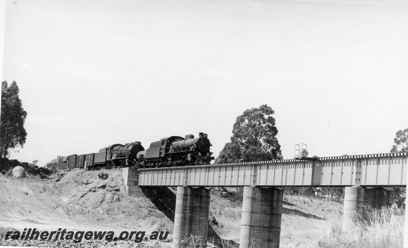 P17381
W class 920 & S class 546 steam locomotives at the head of 104 Goods from Narrogin. The train is crossing the Collie River Bridge. BN line. Good view of bridge pillars and girders.

