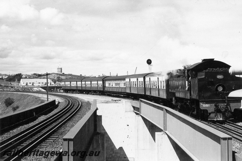 P17631
DM class 581 steam locomotive at the head of a Royal Show Special crossing the Tydeman Road bridge, North Fremantle  ER line. Note bridge girders and automatic signal above coaches.
