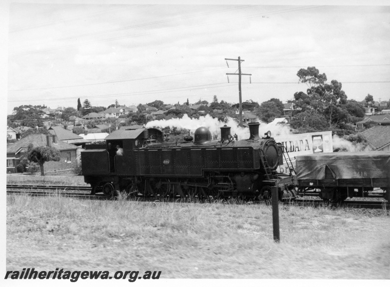 P17649
DD class 594 steam locomotive travelling to Midland and approaching Mount Lawley station. ER line. Note portion of advertising signage.
