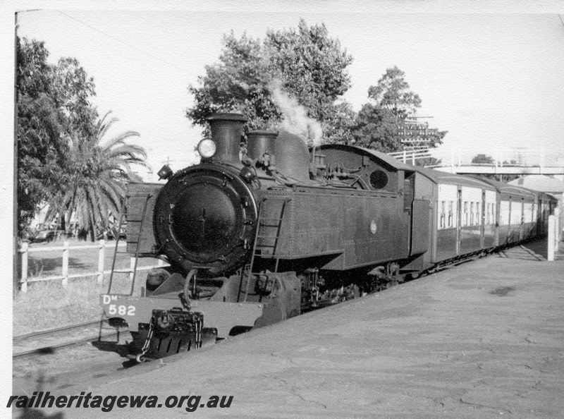 P17664
DM class 582 steam locomotive about to leave Midland with a suburban commuter service to Fremantle. ER line. The train is in the Perth dock. Note the footbridge ramp at the platform.
