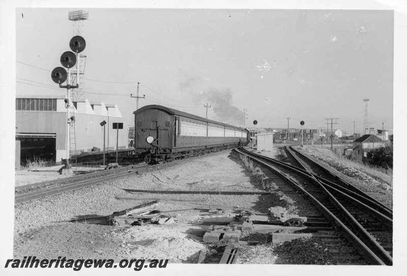 P17682
Steam loco on 6:05 am Fremantle to Perth passenger train, point rodding, search light signals, factory building, North Fremantle, ER line, view from rear of train heading away from camera
