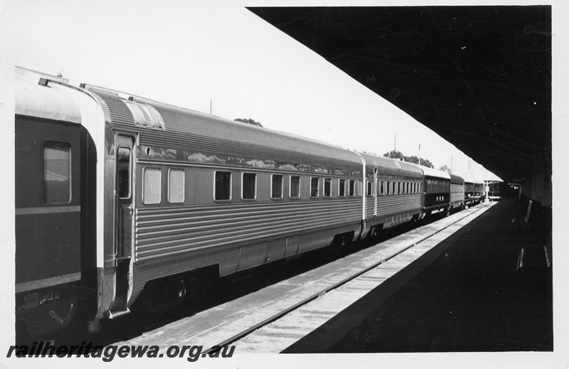 P17781
Rake of passenger carriages including stainless steel cars, adjacent to platform with roof, rear and side view, c1966
