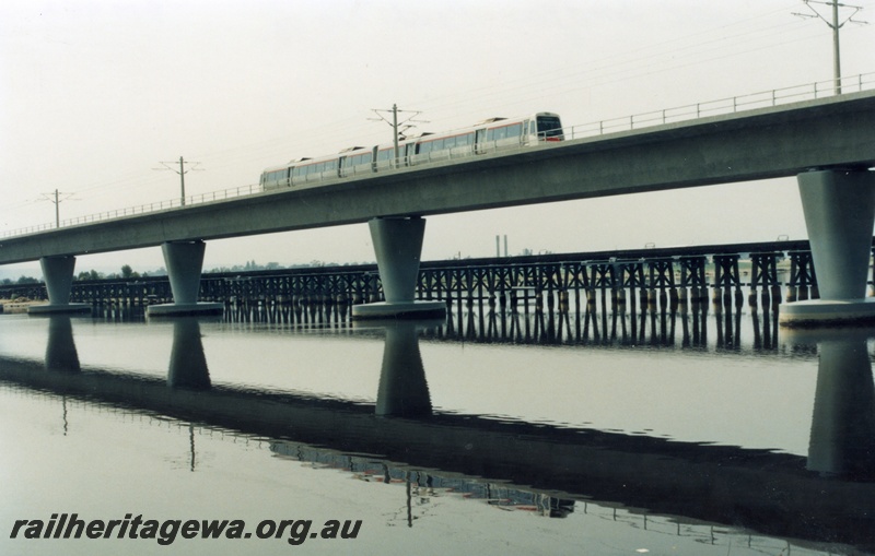 P17953
AEA class EMU, two railcar set, crossing concrete bridge over Swan River, old trestle bridge in background, Perth, river reflection of train and bridge
