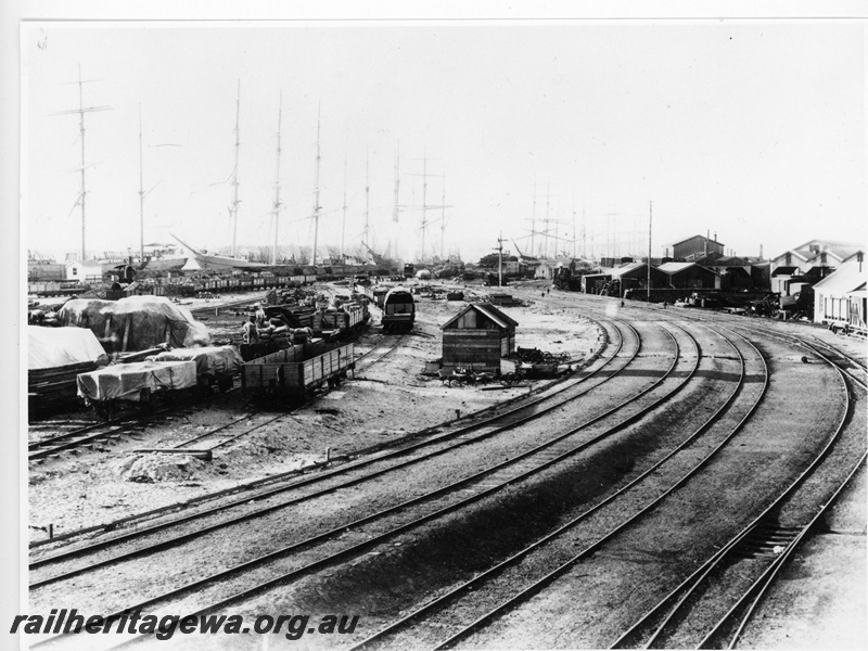 P20027
Port and yard, rakes of wagons, multiple tracks, points, sailing ships with masts, signals, trackside building, industrial buildings, Fremantle, ER line
