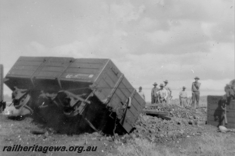 P21222
Derailment on Wiluna line 7 of 7, wagon tipped on side, manganese ore spilt from wagons, work crew, GN line, trackside view
