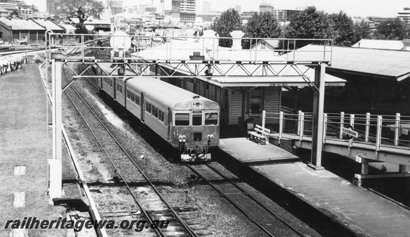 P21621
Suburban 2 car DMU set, Armadale bound, at platform, station building, pedestrian ramp, signal gantry, city background, Claisebrook, SWR line, side and end view from elevated position
