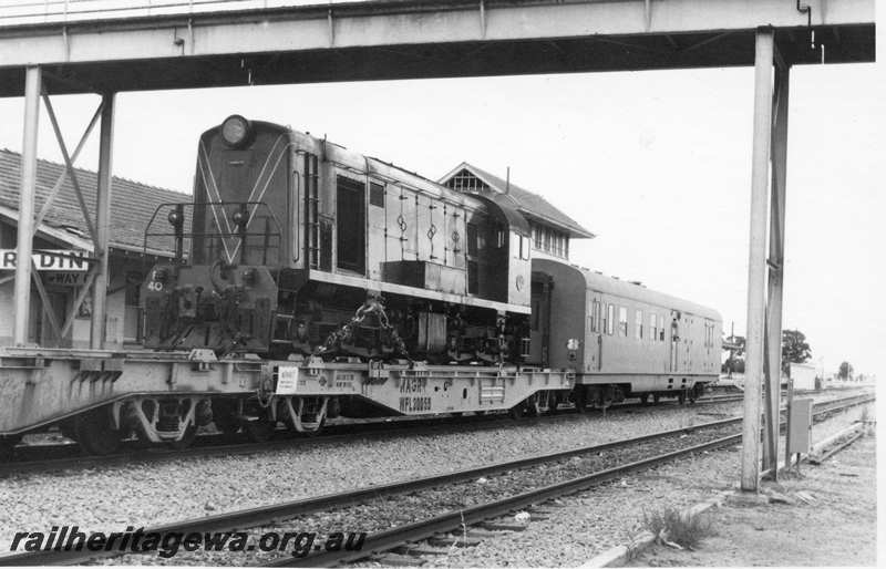 P21718
Former MRWA F class 40, loaded onto flat wagon WFL class 30059, van, part of eastbound  freight train, station building, overhead bridge, Merredin, EGR line, end and side view
