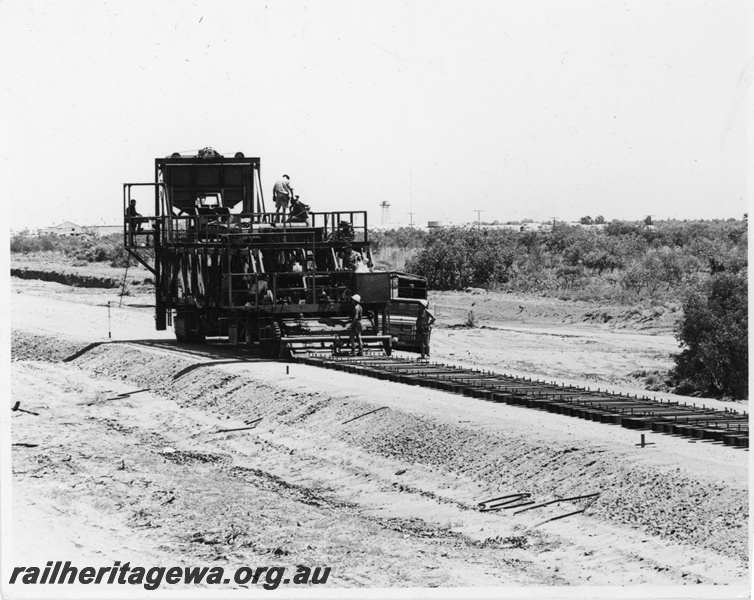 P22422
Tiematic machine laying sleepers, formation, workers, ground level view
