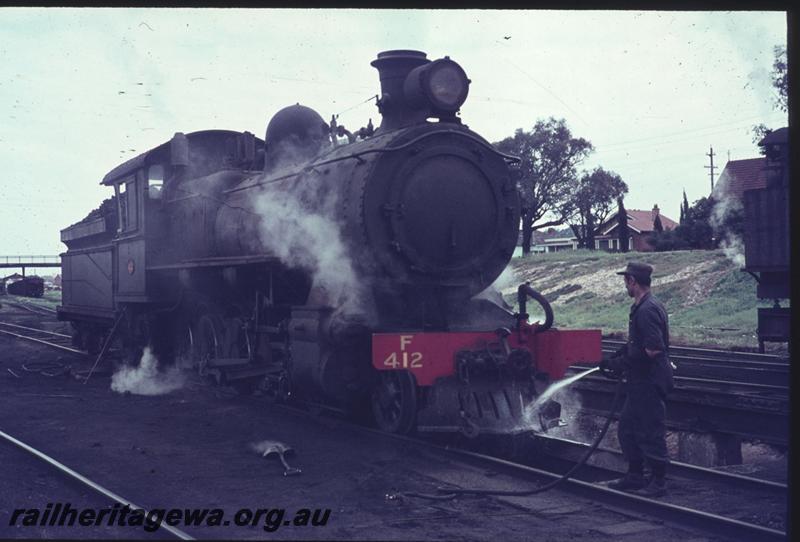 T02295
F class 412, East Perth loco depot, crew member hosing the cowcatcher.
