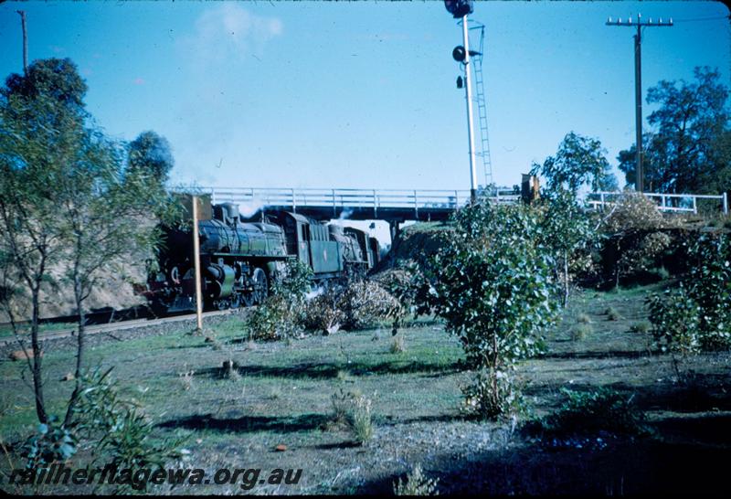 T03242
PM class double heading with a W class, Swan View, ER line, passing under road bridge at east end of station, goods train, shows position of signal.
