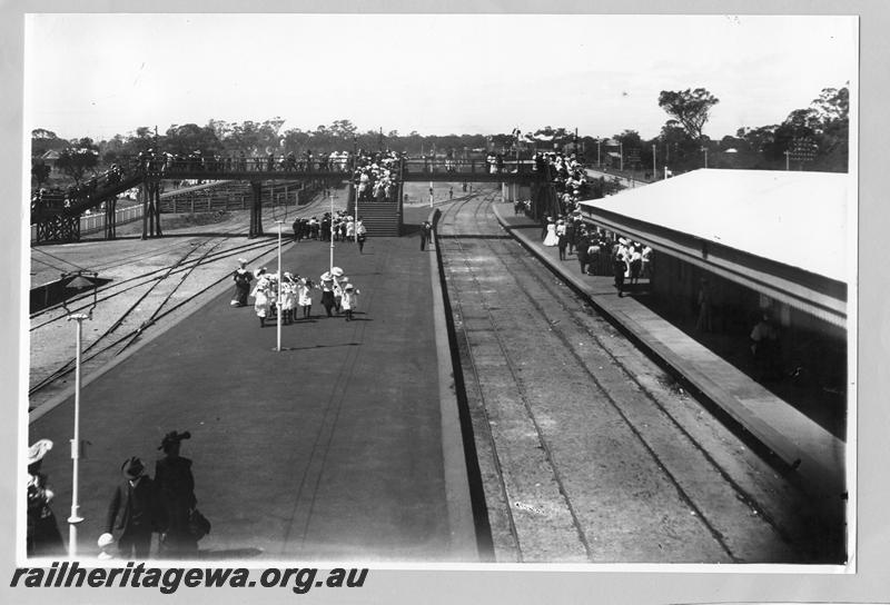 P00383
Station buildings, platform, footbridge, trackwork, Claremont Station, crowds from the Royal Show entering the station, elevated view looking along the platform.
