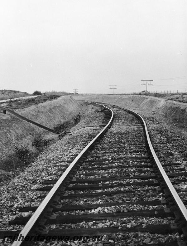 P00398
Track, distorted due to derailment of an iron ore train near Kellerberrin, view along the track,  date of the derailment 19/2/1974
