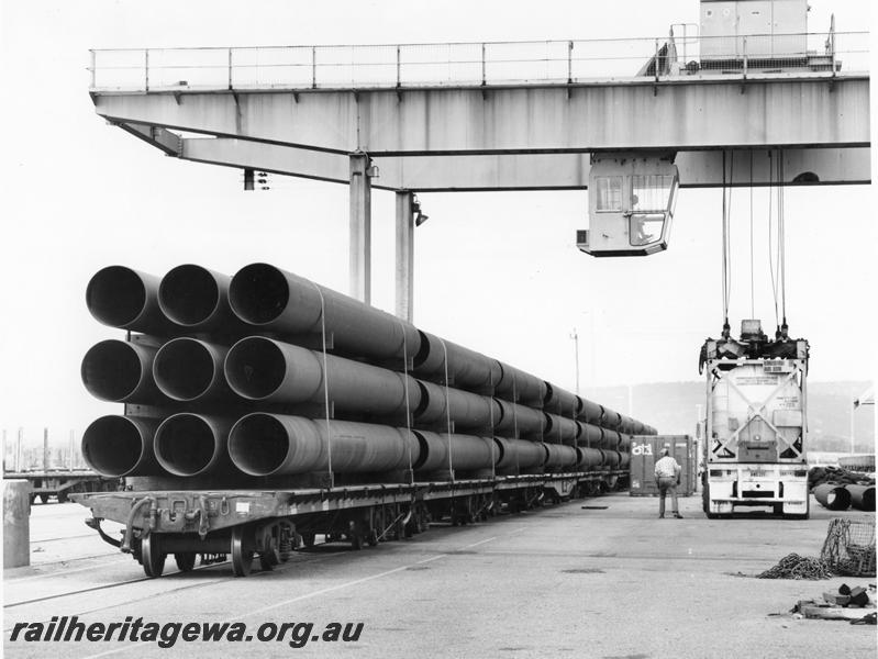 P00406
Bogie flat wagons loaded with pipes for the North West shelf gas pipeline, overhead gantry crane, Kewdale, view along the row of wagons.

