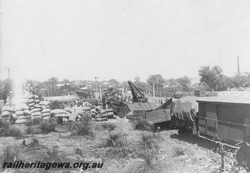 P00545
Derailment at Claremont on the 15th January 1910, view shows a hand crane, derailed and smashed wagons, looking west towards Claremont station.
