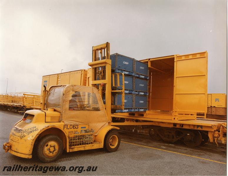 P00785
QUA class flat wagon with container, forklift, palletised loads being loaded into container
