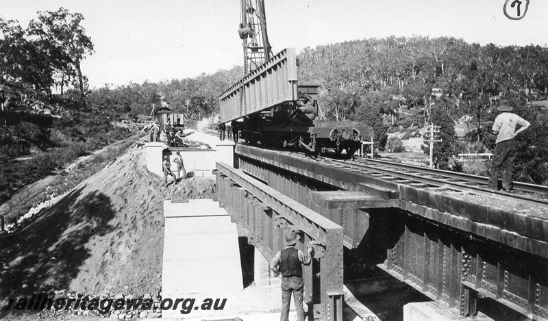 P01434
9 of 13 images of the construction of the duplicate steel girder bridge No.1 at 16 miles 25 chains on the ER through the John Forrest National Park, main girder being placed into position on pylons.
