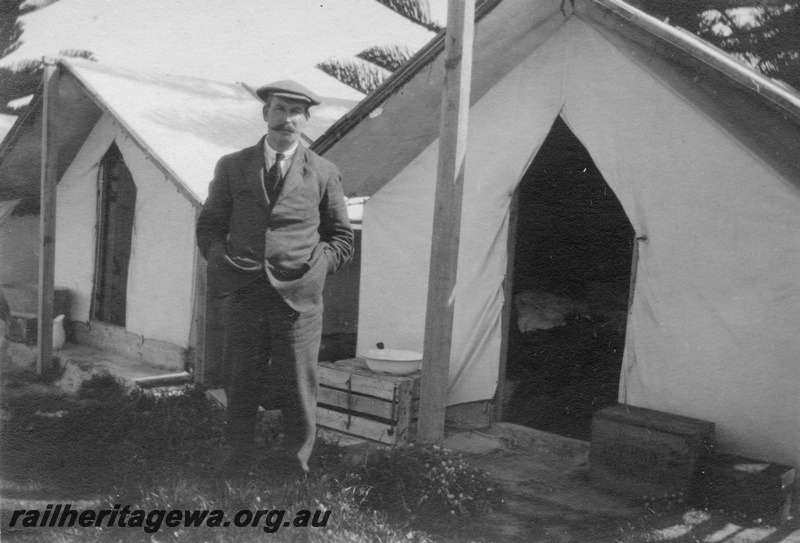 P02096
17 of 44 views of the construction of the railway at Esperance, CE line taken by Cedric Stewart, the resident WAGR engineer, worker's tents with well dressed man posing in front of the entrance to a tent
