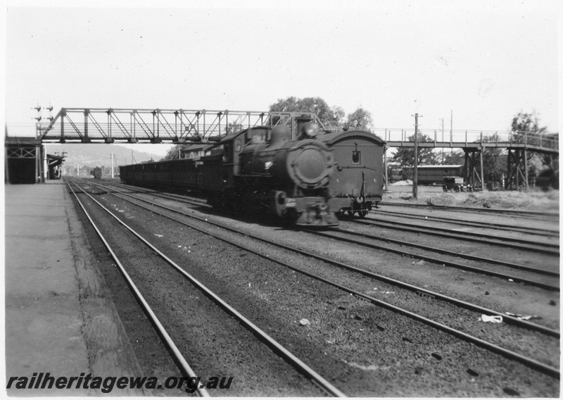 P02674
FS class 44 4-8-0 steam locomotive running light engine, side and front view, footbridge, yard tracks, Midland Junction, ER line.
