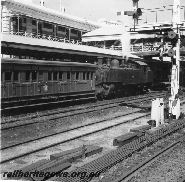 P02682
DD class steam locomotive, front and side view, AE class suburban passenger carriage, side view, signals, signal rodding, covered footbridge, Perth, ER line.
