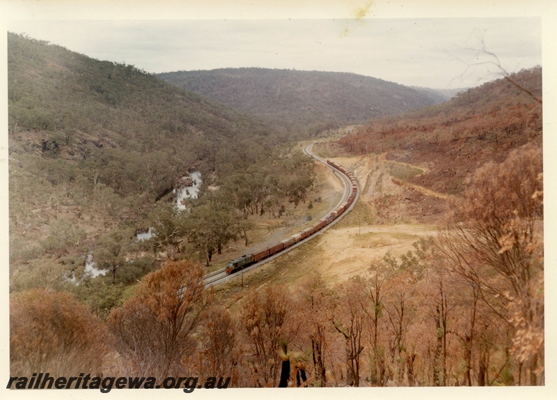 P03996
XA class diesel locomotive with red drop plate, in green with red and yellow stripe livery, on goods train, elevated view, Avon Valley. 
