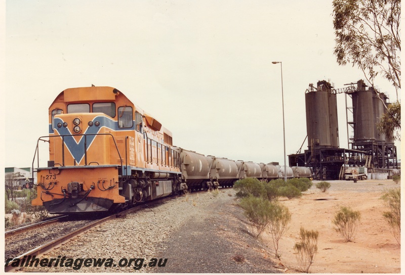 P04151
3 of 3, L class 273 standard gauge diesel in Westrail orange livery, front and side view, on nickel train of WNA class nickel ore wagons being loaded, Red Mine Kambalda.
