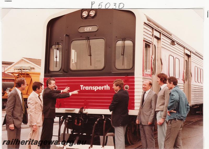 P05030
ADL class 809 railcar, Transperth black and red livery, Westrail dignitaries grouped around front of railcar, possibly the launch of the name Transperth.
