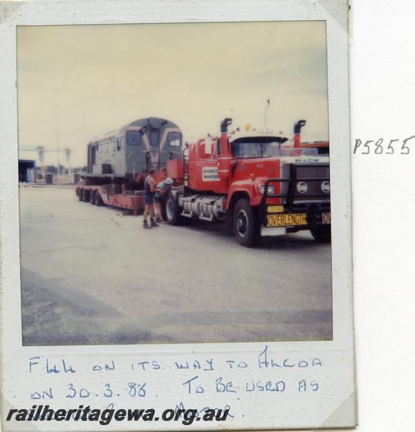 P05855
F class 44, on low loader on way to Alcoa to be used as a sludge pump motor. Polaroid print

