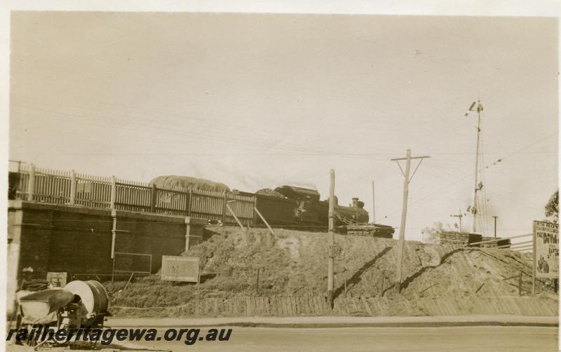 P06200
Goods train crossing over the Mount Lawley Subway, cement mixer on road verge in foreground
