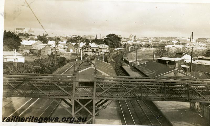 P06269
Footbridge, station buildings, signal gantry, East Perth, view from signal box looking towards Perth. Train No.86 in background
