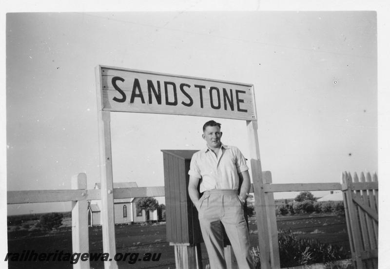 P06701
Fireman A. Livingstone photographed under the nameboard of Sandstone Station, NR line
