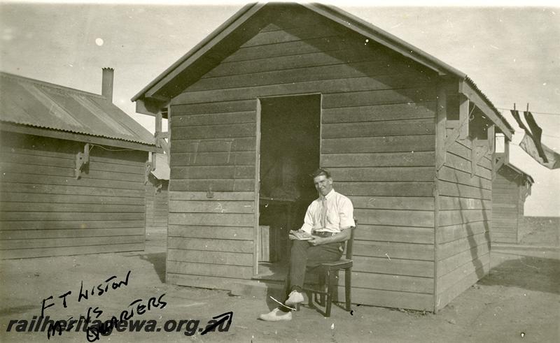 P06964
Men's quarters building, Yalgoo? NR line, Mr F. T. Liston sitting in front of cabin

