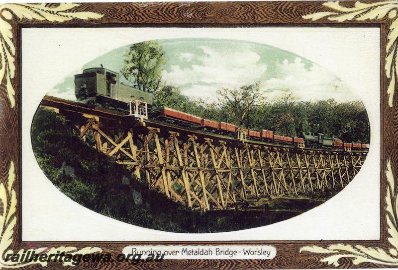 P07184
K class loco hauling a train connected to an E class loco hauling a goods train over the Metaldah Bridge on the now abandoned section of track between Collie and Worsley, BN line, coloured postcard.
