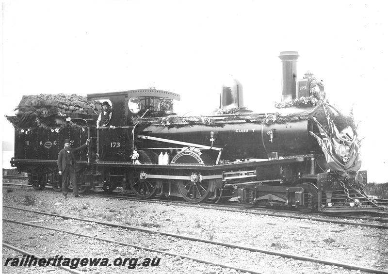 P07189
T class 173, Albany, decorated for the arrival of the new Governor of Western Australia, Sir Arthur Lawley, the decorator, Mr Frank Cook standing at the cab entrance, side and front view
