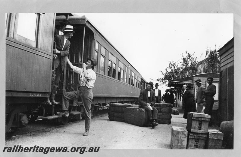 P07810
Station scene at Unknown location, platform ended carriages, station buildings, goods on ground with passengers standing around.

