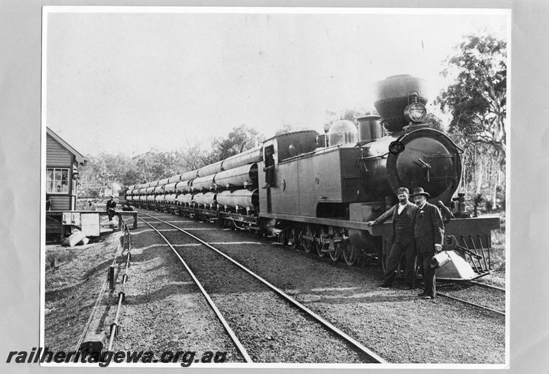 P07820
K class with soft coal chimney, signal box, train of U class wagons loaded with pipes for the Goldfields Water Supply Scheme, location Unknown
