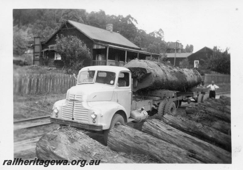 P08258
Millars timber mill, Nanga Brook, house in the centre is the home of the Mill clerk, house on the right is the home of the mill boss, Mr George Geddling. The truck is a Leyland Comet diesel on trial but found to be underpowered Unknown location, truck with log load in front of a workers cottage.
