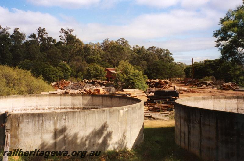 P08322
Abandoned mill site with concrete tanks in the foreground and the loco running shed in the background, Jarrahdale.
