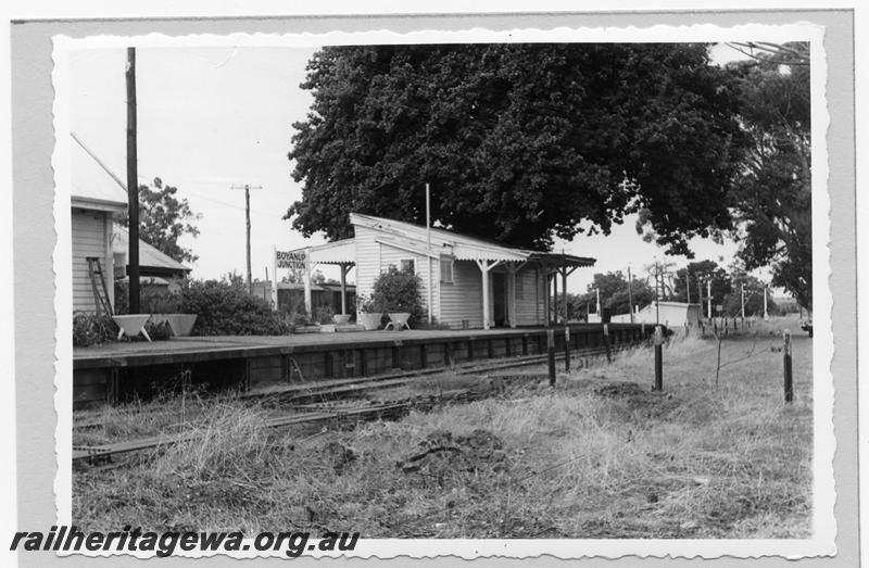 P09398
Boyanup Junction, station buildings, platform, nameboard, tree, signals in distance, point rods, view from down side, wagons in background. PP line.
