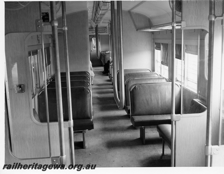 P10721
Interior view of a ADK suburban railcar depicting leather covered seats, stainless steel grab rails and door wind deflectors.
