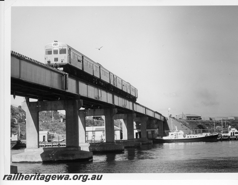 P10730
Four car ADK/ADB suburban railcar set crossing the Swan River at North Fremantle enroute to Perth. Note the Port Authority pilot/work boats tied up at their moorings.
